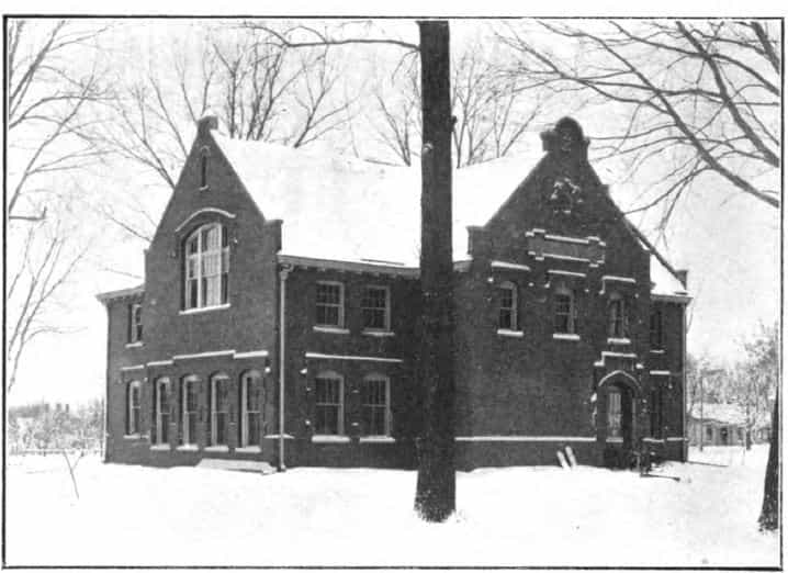 Black and white image showing the front and side exterior of the Simpson College Library. Tree is partially blocking the image. Taken from the 3rd Report of the Iowa Library Commission, coverage 1905-1906. (Published in 1907), opposite page 47.
