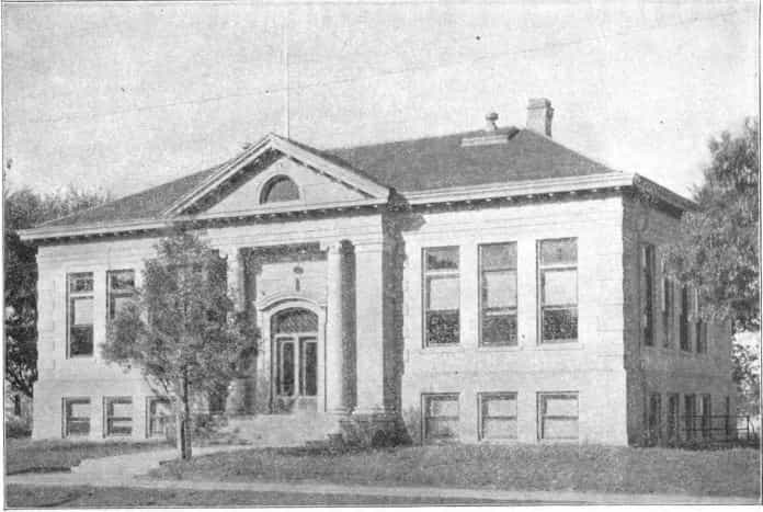 Black and white image showing the front exterior of the Manchester Public Library. 