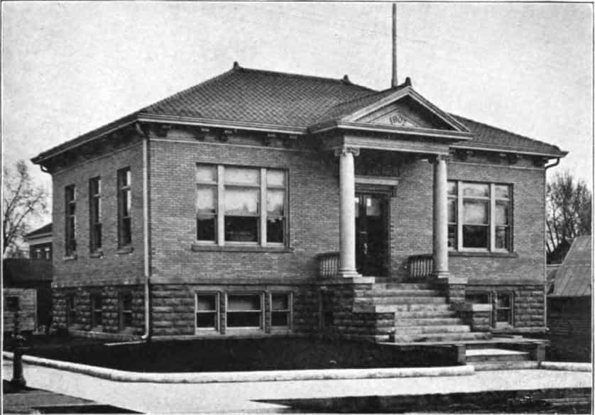 Black and white image showing the exterior front of the DeWitt Public Library. 