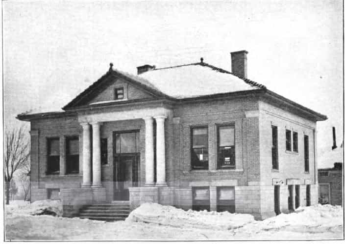 Black and white image depicting the front exterior of the New Hampton Public Library. Taken from the 5th Report of the Iowa Library Commission, coverage 1908-1910. (Published in 1909), unnumbered page between pages 40-41.