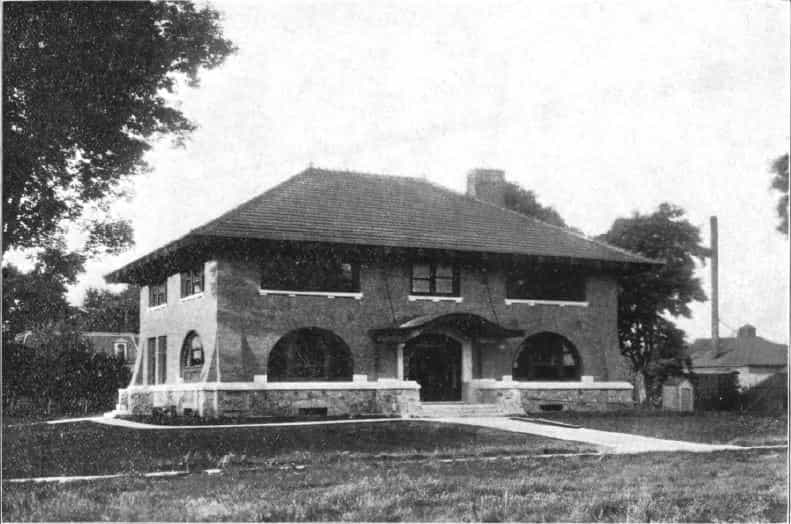 Black and white image showing the front exterior of the Onawa Public Library. The architecture is an example of the "Prairie School" style. Taken from the 5th Report of the Iowa Library Commission, coverage 1908-1910. (Published in 1909), unnumbered page between pages 8-9.