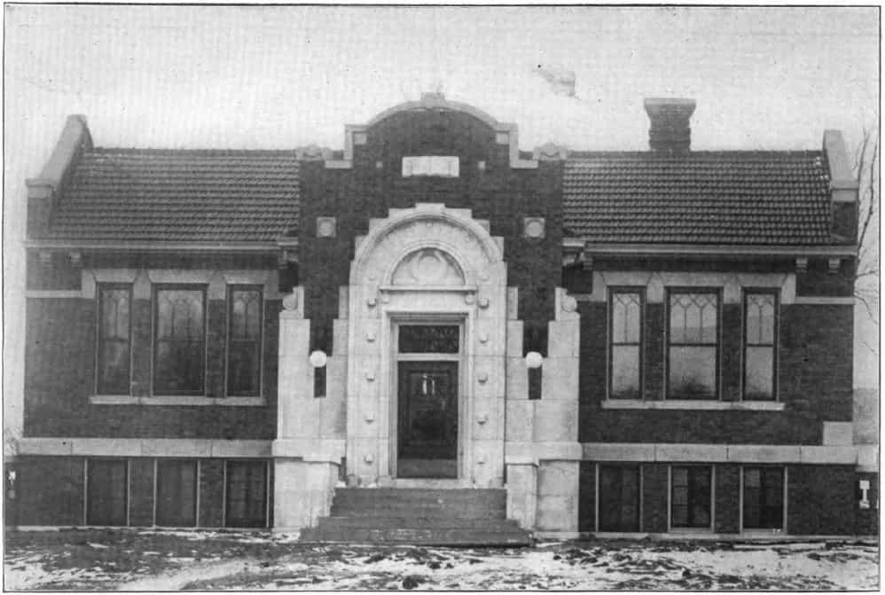 Black and white image depicting the front exterior of the Emmetsburg Public Library. Taken from the 6th Report of the Iowa Library Commission, coverage 1910-1912. (Published in 1913), opposite page 9.