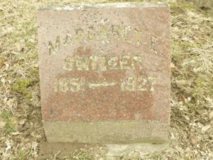 A full color photograph of Margaret Switzer's tombstone, front view. Inscribed is Margaret E. Switzer 1851 - 1927.
